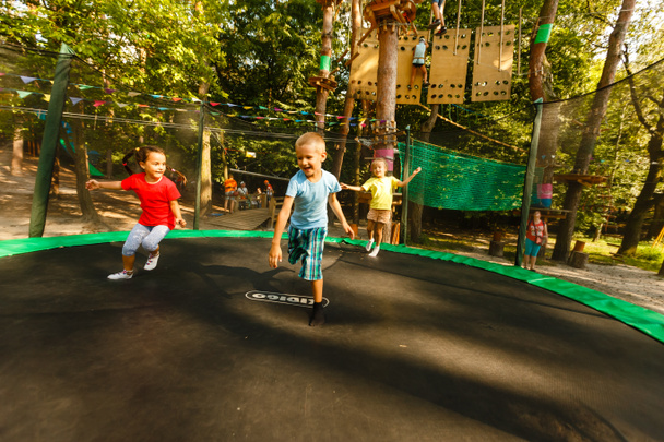 Iloiset lapset hyppivät trampoliinilla äärimmäisissä puistoissa
 - Valokuva, kuva
