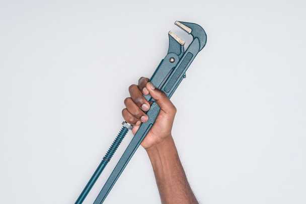 обрізаний знімок афроамериканського чоловіка, який тримає сантехнічний ключ ізольовано на білому
 - Фото, зображення