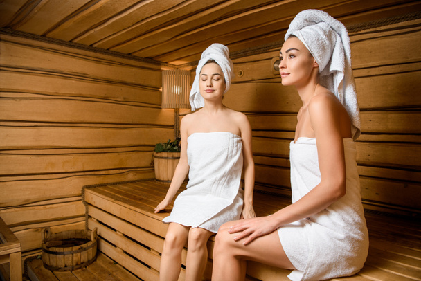 beautiful young women relaxing together in sauna  - Foto, imagen