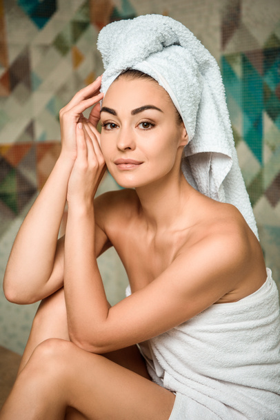 attraente giovane donna in asciugamani guardando la fotocamera mentre seduto nel bagno turco
 - Foto, immagini