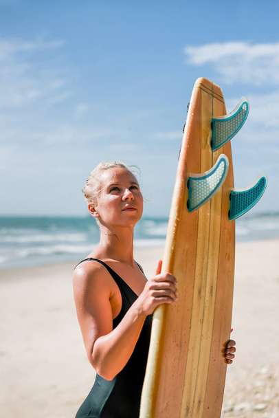 Surfer dziewczyna piękna sportowiec z zarządu o wschodzie słońca. Zdrowy styl życia i aktywny wypoczynek - Zdjęcie, obraz
