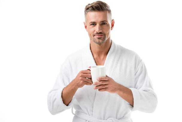 sorrindo homem em roupão segurando xícara de café isolado no branco
 - Foto, Imagem