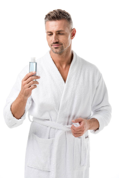 man in bathrobe holding shaving lotion isolated on white - Foto, afbeelding