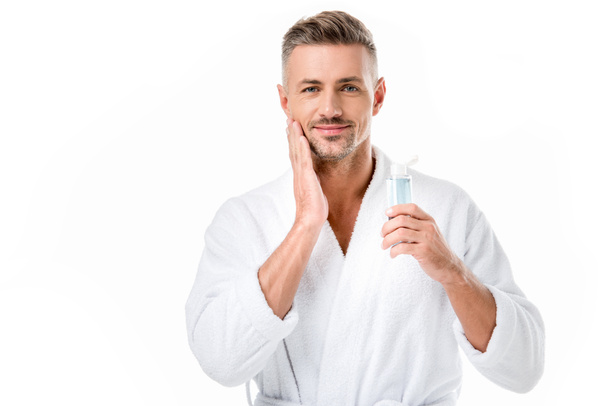 portrait of cheerful man in bathrobe using shaving lotion isolated on white - Foto, Imagem