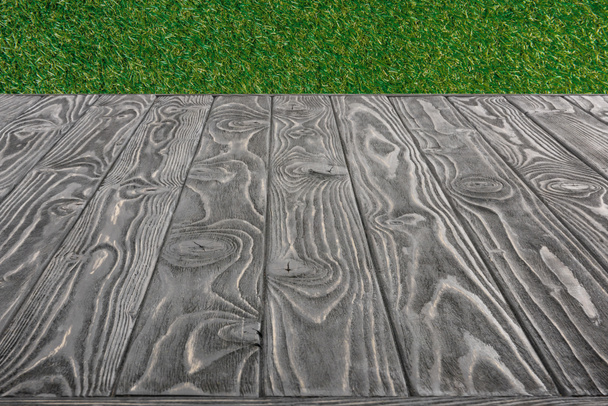  surface of grey wooden planks on green grass background - Foto, imagen
