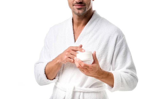 partial view of man in bathrobe holding beauty cream isolated on white - Zdjęcie, obraz