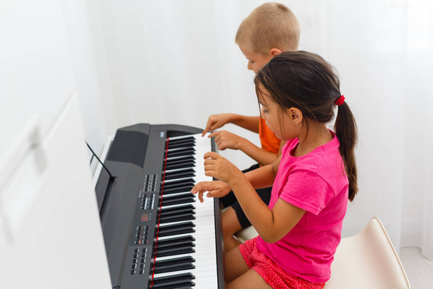 Νεαρό κορίτσι και αγόρι παίζουν στο πληκτρολόγιο  - Φωτογραφία, εικόνα