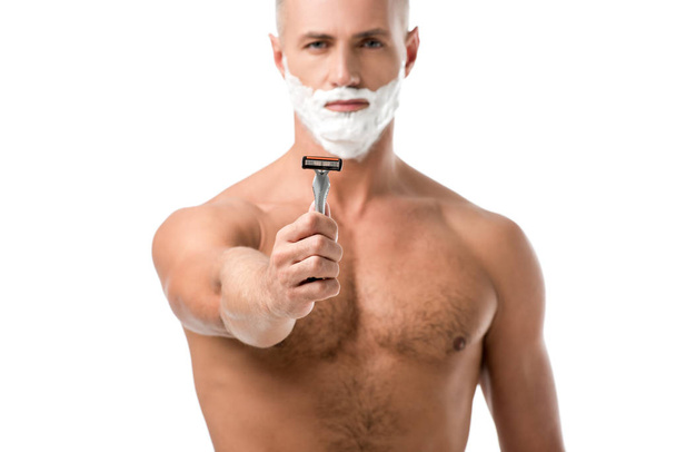 homem com espuma de barbear no rosto mostrando navalha isolada no branco
 - Foto, Imagem