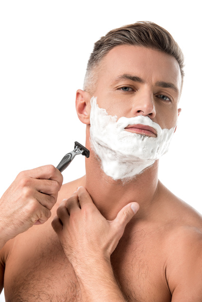 confident man with foam on face shaving with razor isolated on white - Zdjęcie, obraz