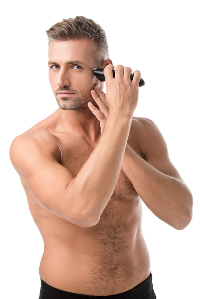 vážný dospělý muž holení s elektrickým frézovacím izolované na bílém - Fotografie, Obrázek