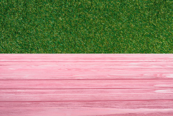 Vorlage aus rosa Holzboden mit grünem Gras auf Hintergrund - Foto, Bild