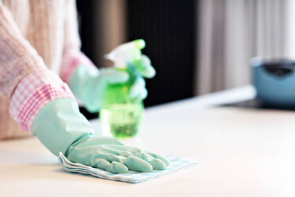 Happy woman cleaning kitchen countertop - Photo, Image