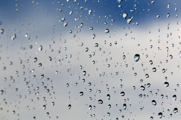 Raindrops on the glass against the blue sky - Fotó, kép