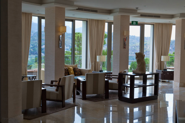 hotellin aula on kallis ikkunoilla ja sohvilla
 - Valokuva, kuva