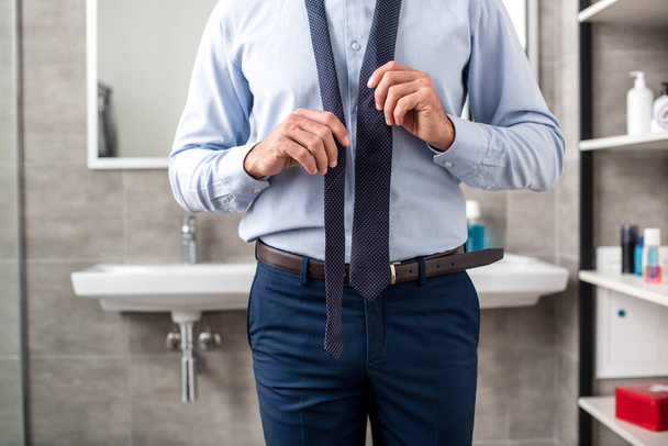 immagine ritagliata di uomo d'affari cravatta legatura in bagno
  - Foto, immagini