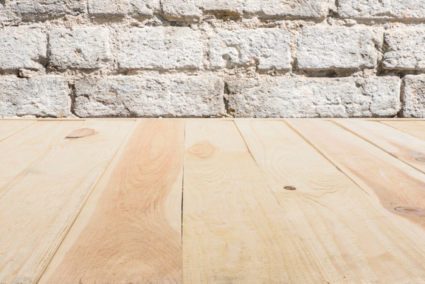 template of beige wooden floor made of planks with brick wall on background - Фото, изображение