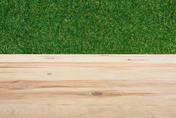 template of beige wooden floor with green grass on background - Foto, afbeelding