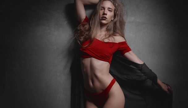 Kırmızı bikini ve genel olarak poz gri duvar arka plan üzerinde siyah güzel genç kadın - Fotoğraf, Görsel