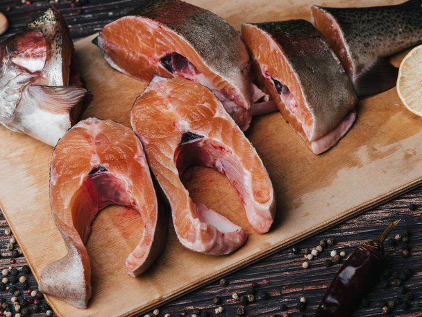 pieces of red fish on the Board on the table. Sliced trout close-up - Zdjęcie, obraz