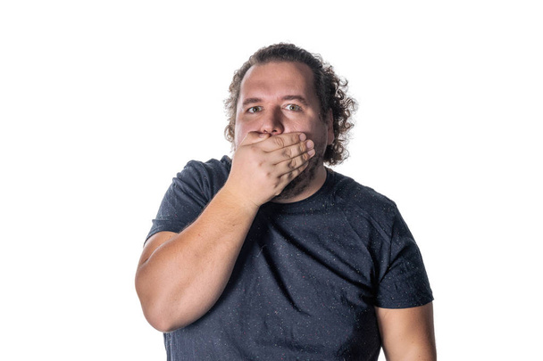 Portrait of amazed man covering his mouth over white background - Photo, image