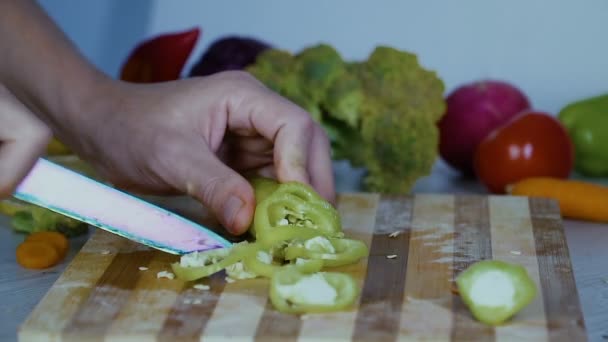 L'uomo sta tagliando le verdure in cucina, affettando peperone verde
 - Filmati, video