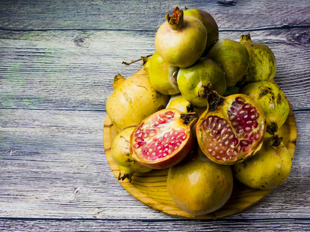 Fruta de granada en un plato de madera
 - Foto, imagen