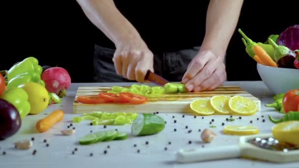 Az ember a vágás zöldség a konyhában, szeletelés zöld színű paprika - Felvétel, videó