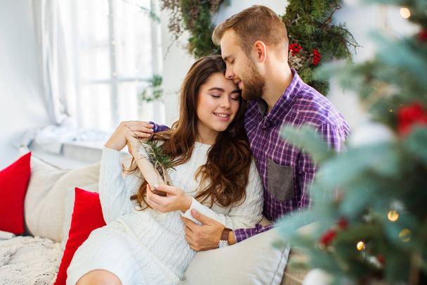 Young happy couple celebrating christmas at home. Christmas and holiday concept. - Foto, Bild