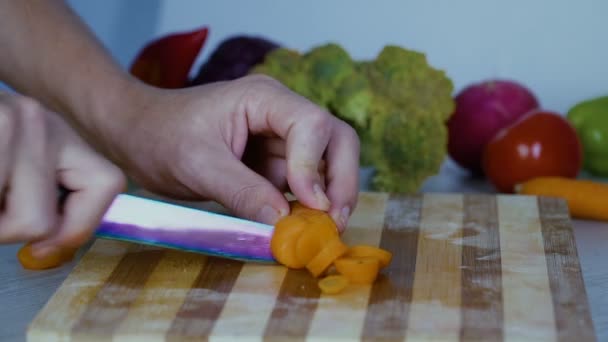 El hombre está cortando verduras en la cocina, rebanando pimiento verde
 - Imágenes, Vídeo