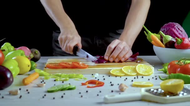Ο άνθρωπος είναι κοπής λαχανικών στην κουζίνα, σε φέτες κόκκινο λάχανο - Πλάνα, βίντεο