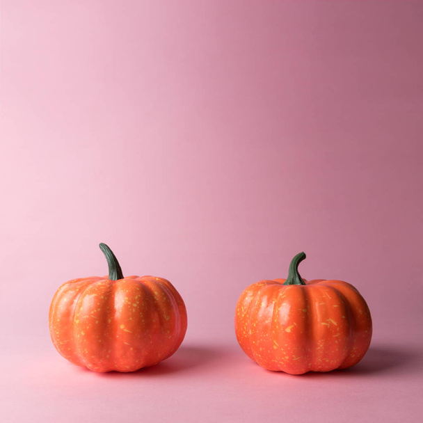 Halloween pumpkin on pastel pink background. Halloween minimal concept. - Фото, изображение