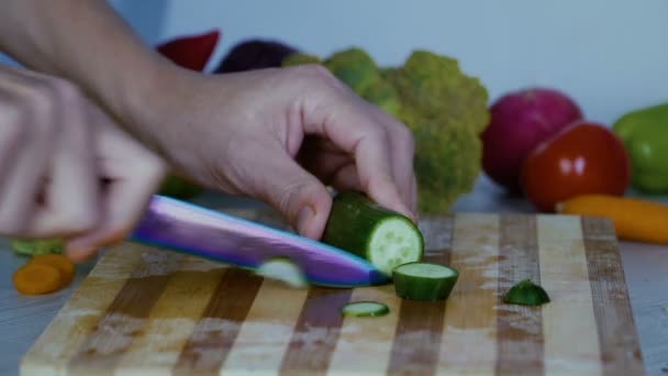 De mens is snijden groenten in de keuken, snijden de komkommer - Video