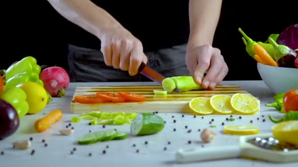 Ο άνθρωπος είναι κοπής λαχανικών στην κουζίνα, σε φέτες αγγούρι - Πλάνα, βίντεο