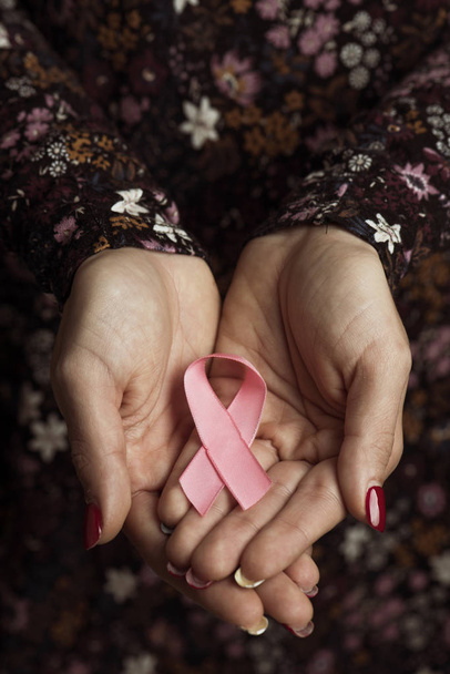 close-up de uma jovem mulher caucasiana com uma fita rosa em suas mãos, para a consciência do câncer de mama
 - Foto, Imagem