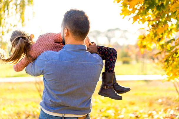 Dad and daughter in the autumn park play laughing - 写真・画像