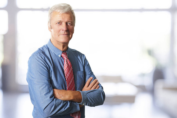 Portrait d'un dirigeant d'entreprise debout au bureau avec les bras croisés
.  - Photo, image