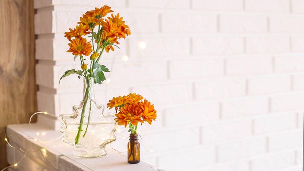 Grandes e pequenos buquês de crisântemos de laranja em vasos no interior de casa brilhante de outono. Conforto e beleza em casa
 - Foto, Imagem
