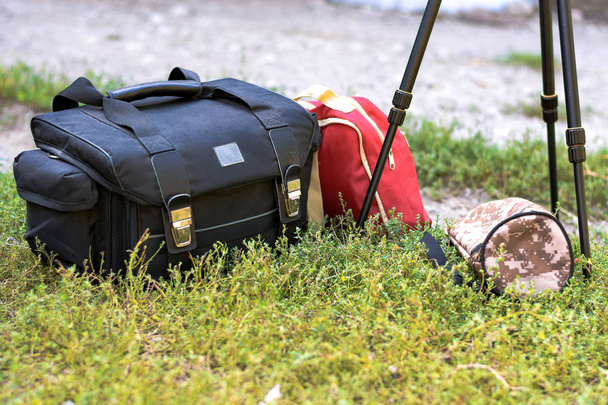 カメラ、三脚、赤いバックパックのバッグです。旅行のためのカメラマンのためのキット. - 写真・画像