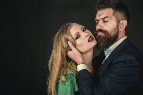 Keeping romance alive. Intimate couple in fashion clothing. Fashion style and hair care. Style icons. They both love fashion. Couple in love. Bearded man hug woman with long hair, copy space - Photo, Image