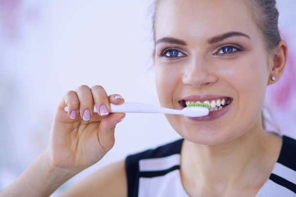 Молода красива дівчина підтримує гігієну порожнини рота зубною щіткою
. - Фото, зображення