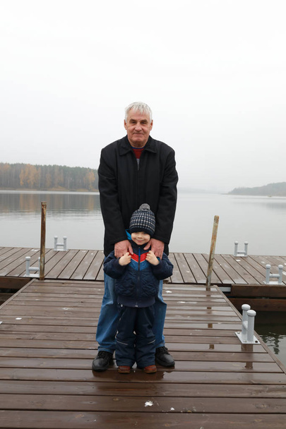Grandfather with his grandson posing on pier, Zaslavsky reservoir, Minsk region - Valokuva, kuva
