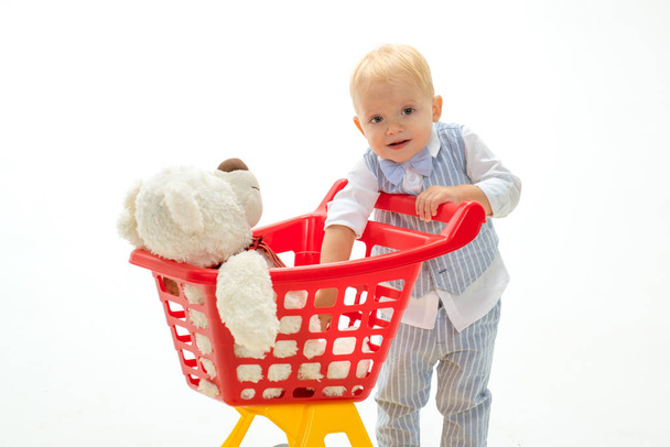little boy child in toy shop. little boy go shopping with full cart. savings on purchases. happy childhood and care. shopping for children. Friendly shop assistant. Perfect quality. Pleasant price - Фото, зображення
