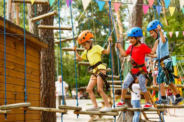 Lachende jongen en meisjes in helmen spelen in extreme Park - Foto, afbeelding