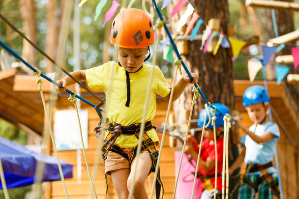 Mała dziewczynka wspinaczkowa na linach w ekstremalnym parku  - Zdjęcie, obraz