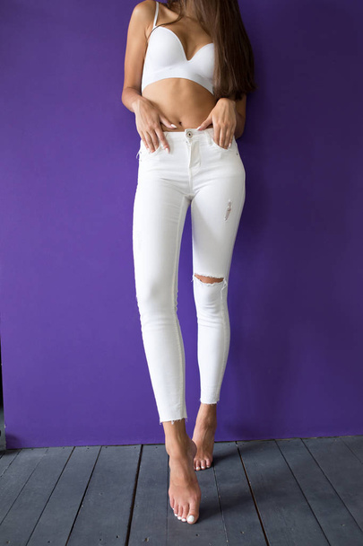 Female legs in white jeans on a bright background. Mock-up. - Foto, Bild