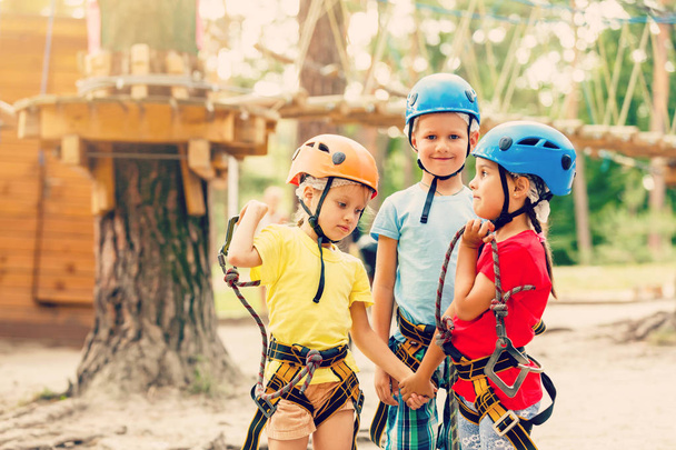Sorrindo menino e meninas em capacetes jogando no parque extremo
 - Foto, Imagem
