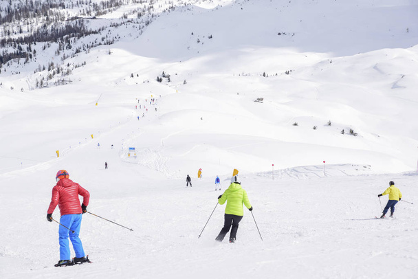 os picos das montanhas dos Alpes cobertos de neve. as pistas de esqui lotadas com esquiadores em um dia ensolarado de inverno
 - Foto, Imagem