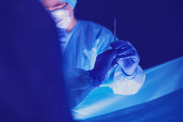 Doctors team in surgery in a dark background. - Photo, image