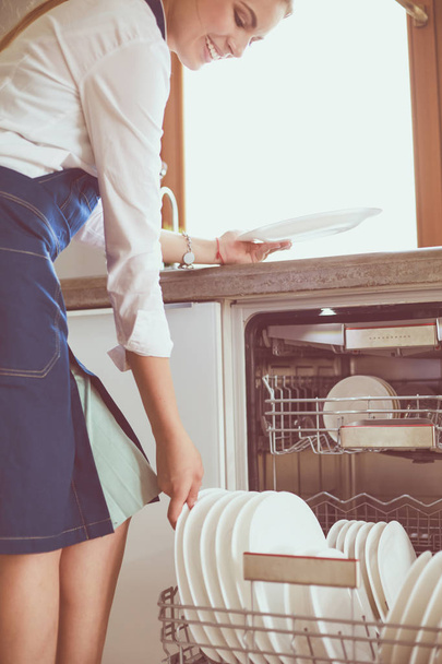 Dishwasher. Young woman in the Kitchen doing Housework. Wash-up - Фото, изображение