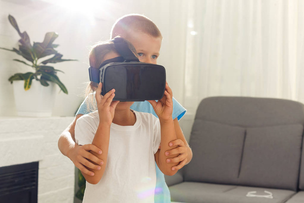 Αδελφός και αδελφή χρησιμοποιώντας κάσκες εικονικής πραγματικότητας στο σαλόνι - Φωτογραφία, εικόνα